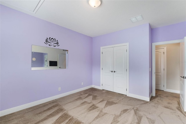 unfurnished bedroom featuring a closet and light colored carpet