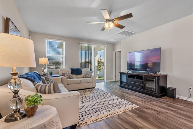 living room featuring hardwood / wood-style flooring, a textured ceiling, and ceiling fan