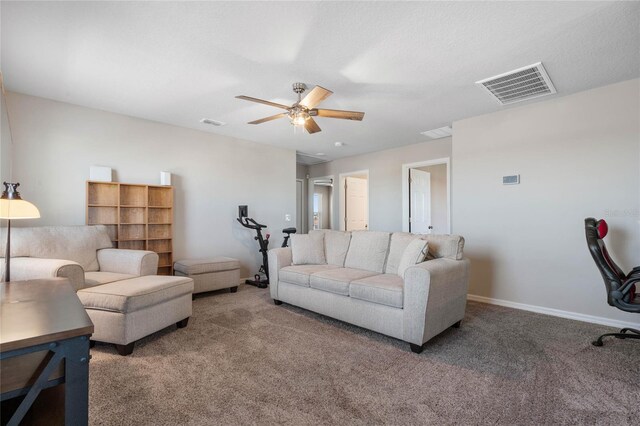 living room with ceiling fan and dark colored carpet