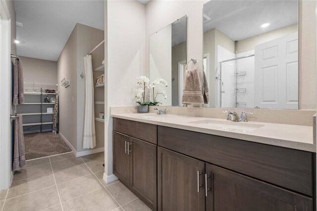 bathroom featuring tile patterned floors, walk in shower, and vanity