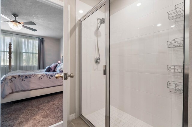 bathroom with ceiling fan and a shower with door