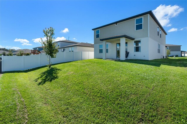 back of house featuring a yard