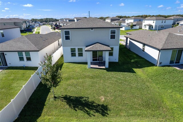 back of house with a lawn and a patio