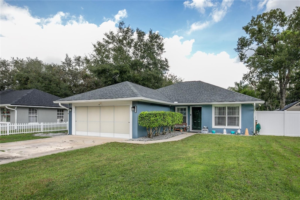 ranch-style house with a garage and a front lawn