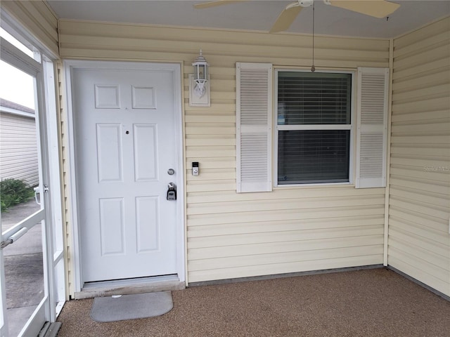 view of exterior entry featuring ceiling fan