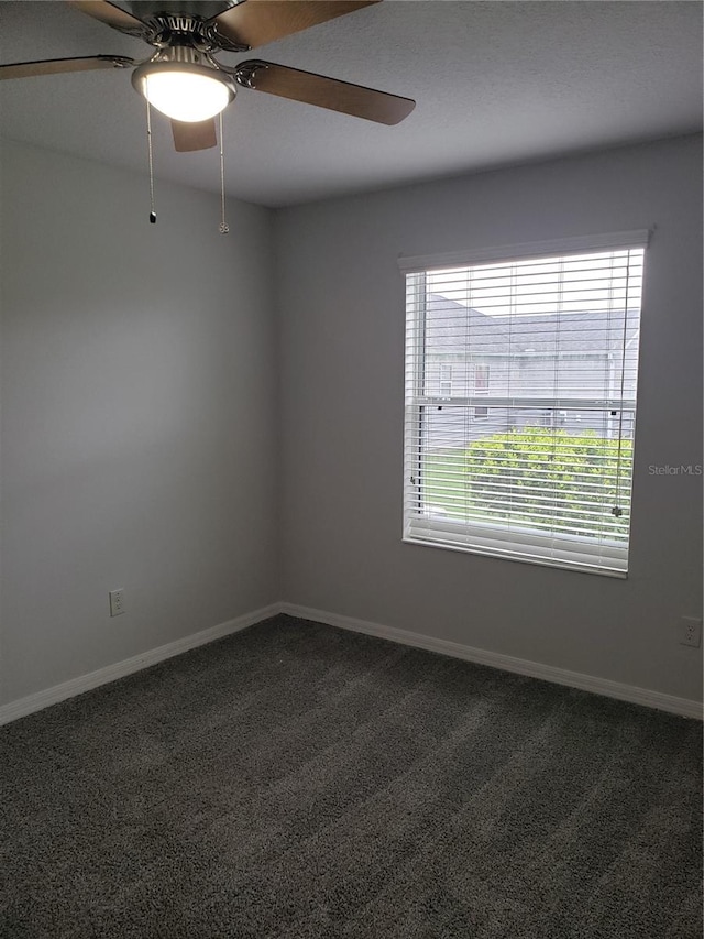 spare room with ceiling fan and carpet