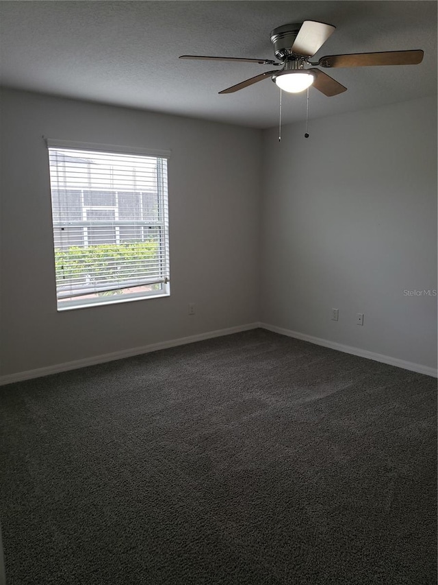 empty room featuring ceiling fan and carpet