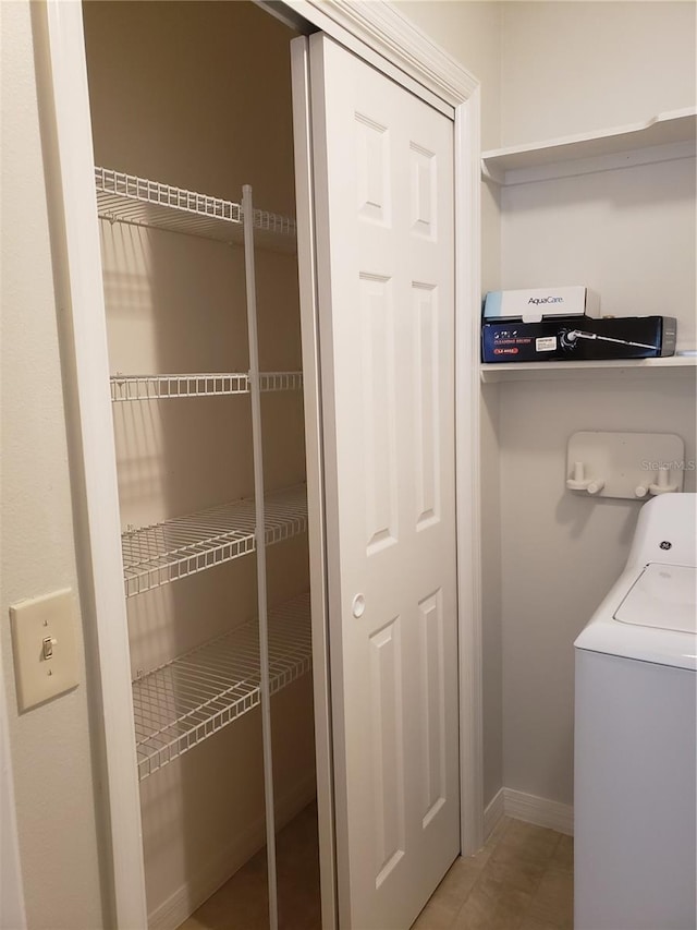 clothes washing area with washer / dryer and tile patterned floors