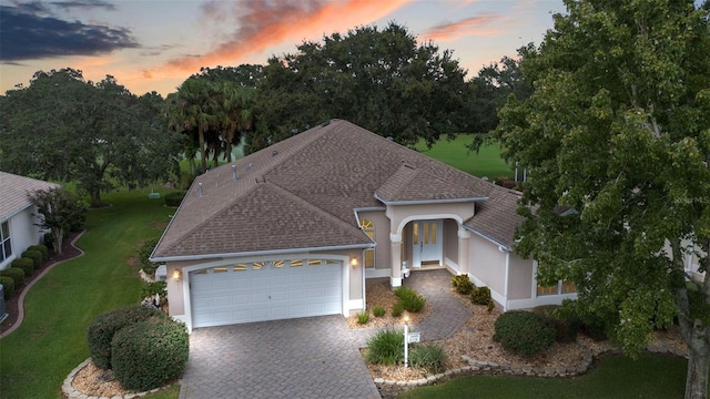 view of front facade with a yard and a garage