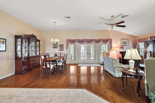 dining room featuring lofted ceiling, light hardwood / wood-style flooring, and ceiling fan with notable chandelier