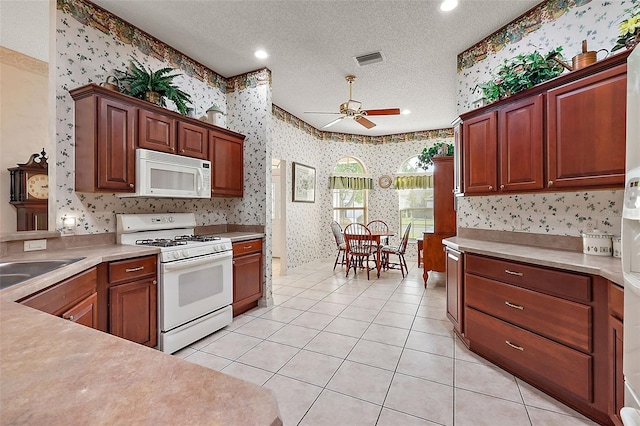 kitchen with white appliances, ceiling fan, a textured ceiling, and light tile patterned flooring