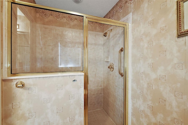 bathroom with a textured ceiling and a shower with shower door