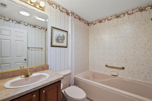 full bathroom featuring vanity, toilet, a textured ceiling, and tiled shower / bath