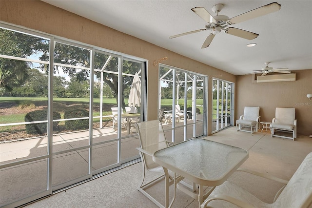 sunroom featuring an AC wall unit, a healthy amount of sunlight, and ceiling fan