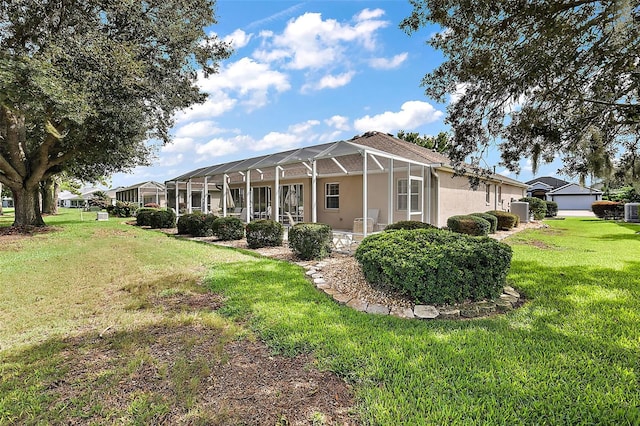 exterior space featuring a lanai, a garage, and a front yard