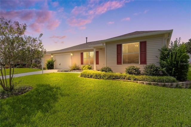 single story home featuring a yard and a garage