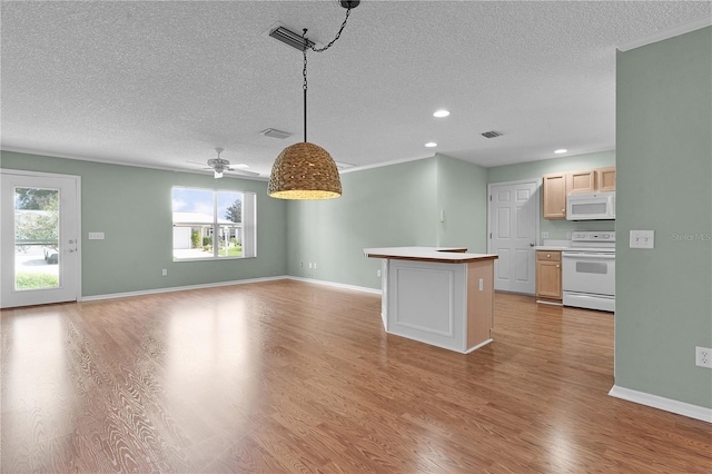 kitchen with light wood-type flooring, a center island, white appliances, light brown cabinetry, and decorative light fixtures