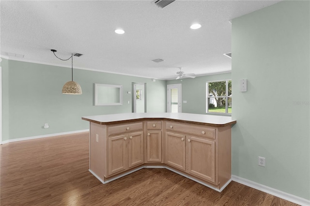 kitchen featuring light brown cabinetry, pendant lighting, a textured ceiling, and light hardwood / wood-style floors