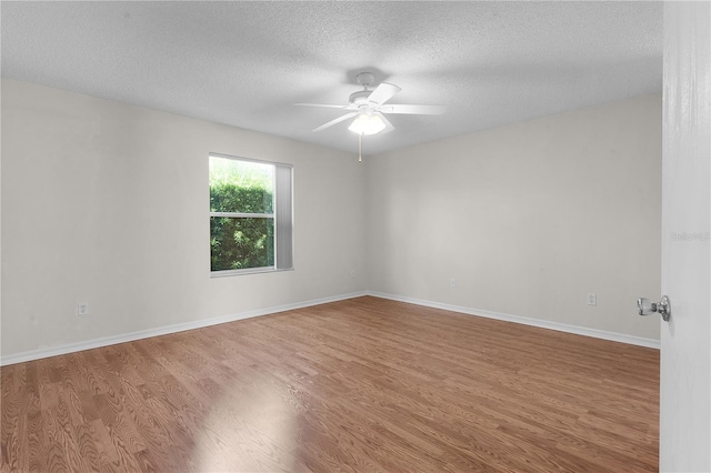 empty room featuring ceiling fan, hardwood / wood-style flooring, and a textured ceiling