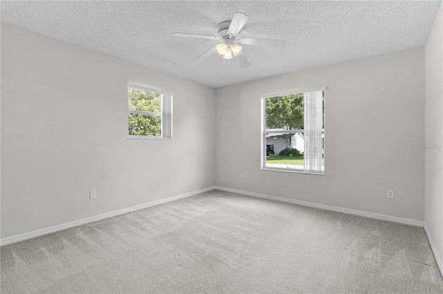 carpeted empty room featuring ceiling fan and a textured ceiling