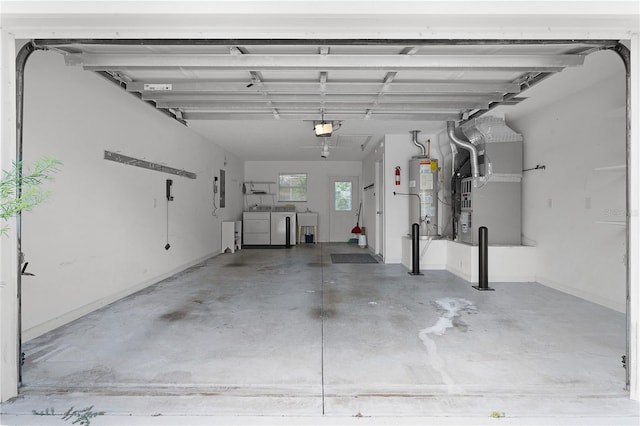 garage featuring a garage door opener, heating unit, sink, gas water heater, and washing machine and dryer