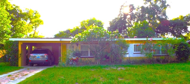 view of front of home with a front yard and a carport