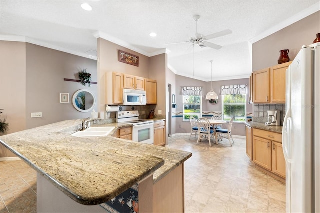 kitchen featuring kitchen peninsula, a kitchen bar, pendant lighting, sink, and white appliances