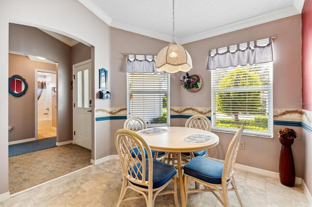 dining space featuring ornamental molding, light tile patterned flooring, a textured ceiling, and plenty of natural light