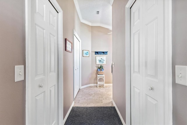 hall featuring crown molding and a textured ceiling