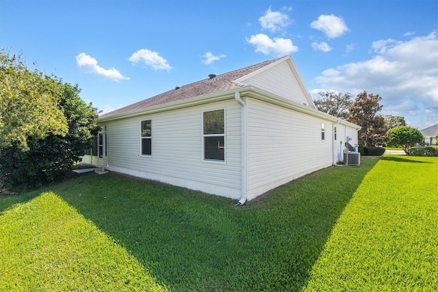 view of side of home with central air condition unit and a lawn