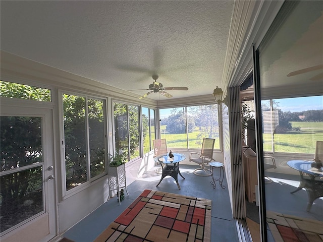 unfurnished sunroom with ceiling fan