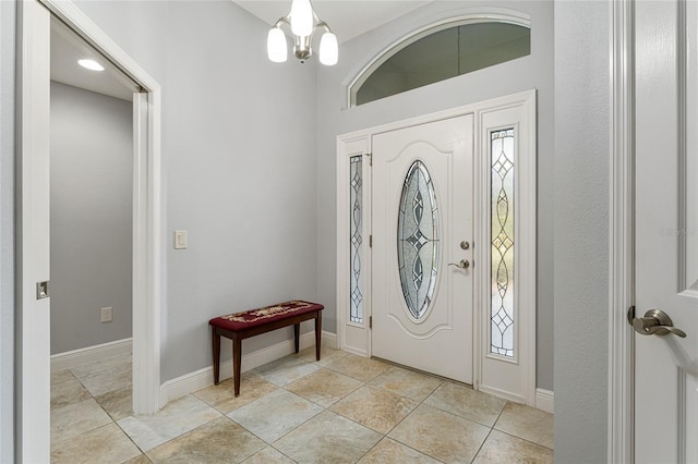 tiled entryway with an inviting chandelier