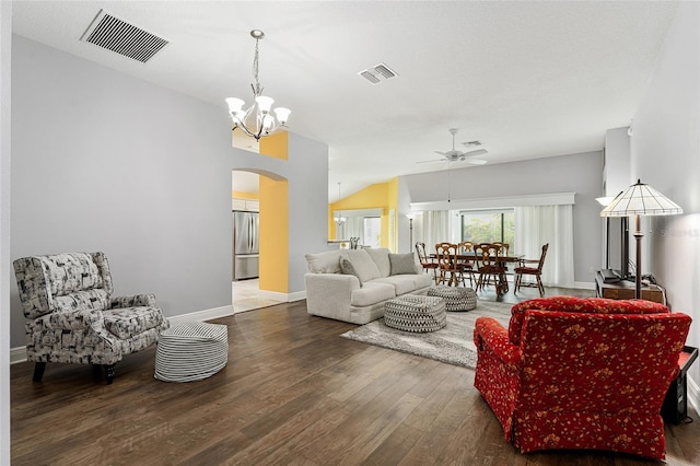 living room featuring ceiling fan with notable chandelier, lofted ceiling, and dark wood-type flooring