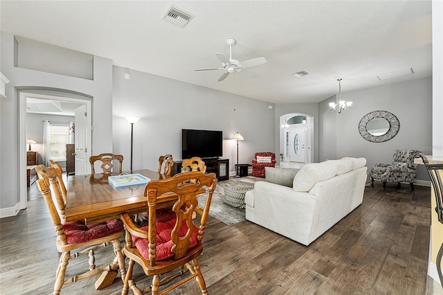 living room with ceiling fan with notable chandelier and dark wood-type flooring