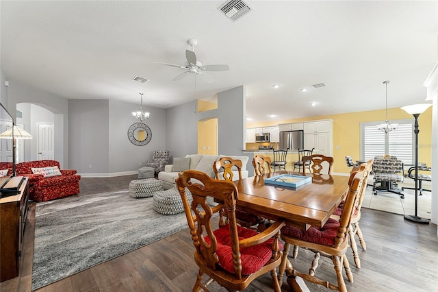 dining space featuring ceiling fan with notable chandelier and hardwood / wood-style flooring