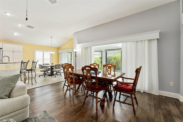 dining area featuring hardwood / wood-style flooring, plenty of natural light, lofted ceiling, and a textured ceiling