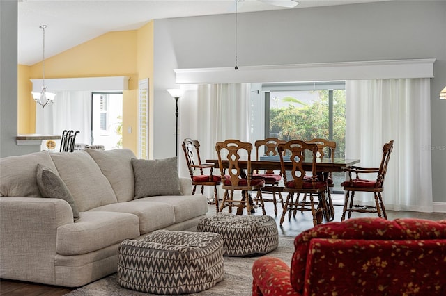 living room with lofted ceiling, a notable chandelier, and wood-type flooring