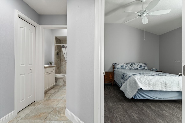 bedroom featuring ensuite bathroom, ceiling fan, light hardwood / wood-style flooring, a closet, and vaulted ceiling