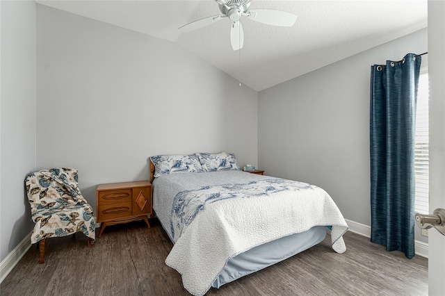 bedroom with vaulted ceiling, hardwood / wood-style flooring, a textured ceiling, and ceiling fan