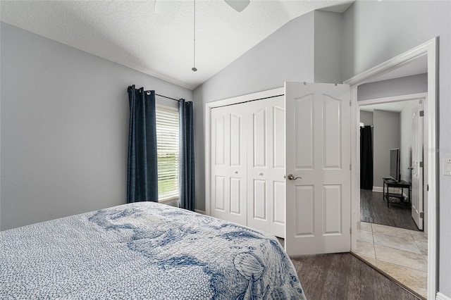 bedroom with wood-type flooring, a closet, vaulted ceiling, and ceiling fan