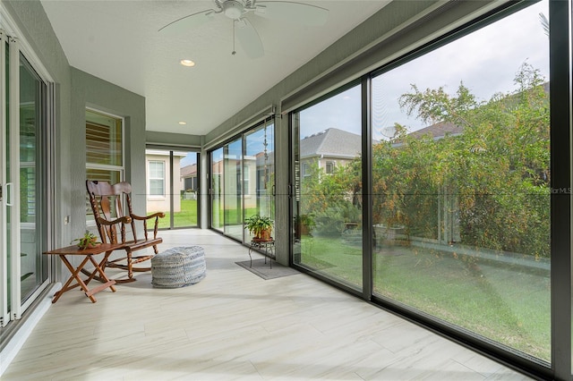 unfurnished sunroom with ceiling fan