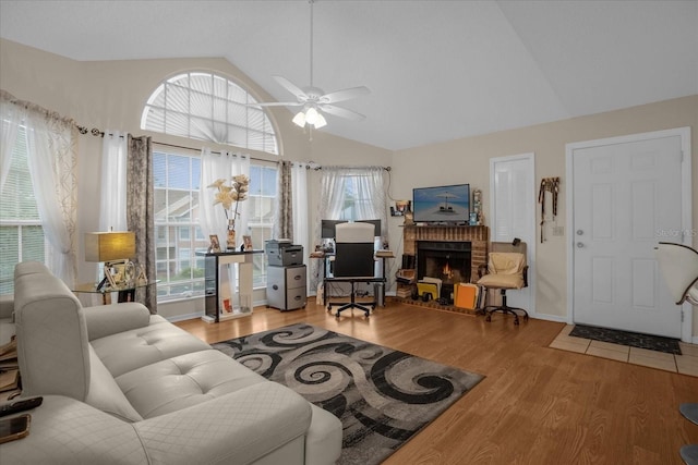 living room with a fireplace, hardwood / wood-style floors, vaulted ceiling, and ceiling fan