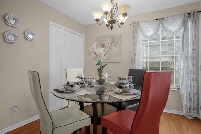 dining space featuring hardwood / wood-style flooring and an inviting chandelier