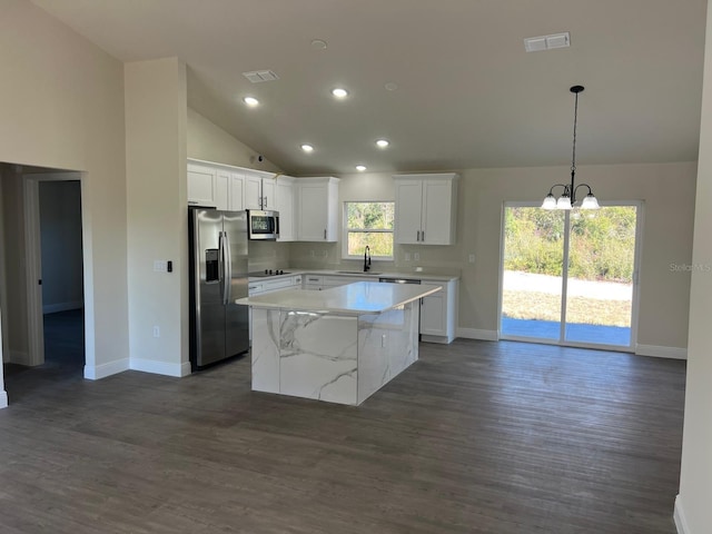 kitchen with white cabinets, appliances with stainless steel finishes, a kitchen island, and sink