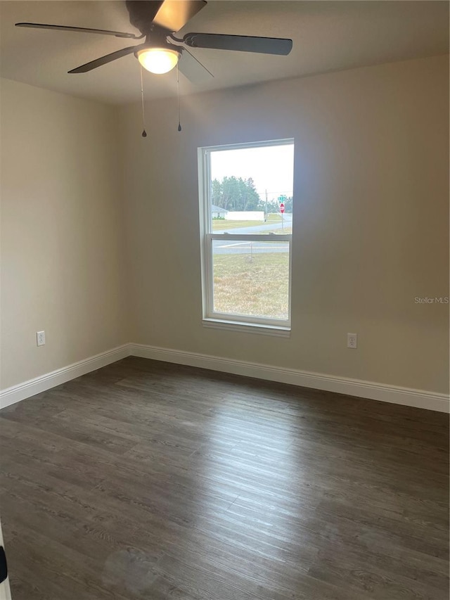 spare room with dark hardwood / wood-style floors and ceiling fan