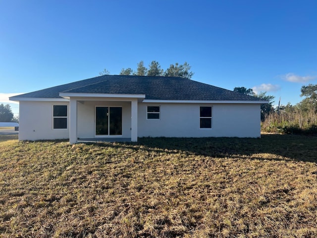 back of property featuring a lawn