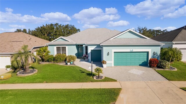 25304 Forest Oak Ct, Leesburg, FL 34748 - ranch-style house featuring decorative driveway, a shingled roof, an attached garage, a front yard, and stucco siding