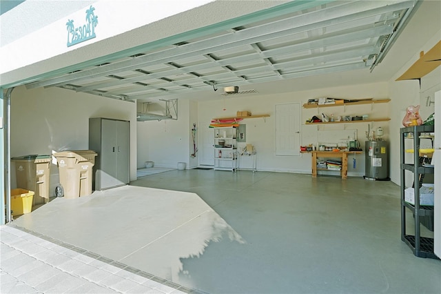 garage featuring water heater, a workshop area, and electric panel