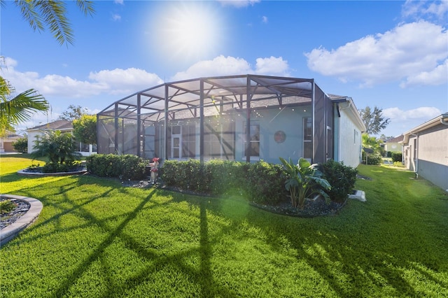 rear view of property featuring glass enclosure and a yard