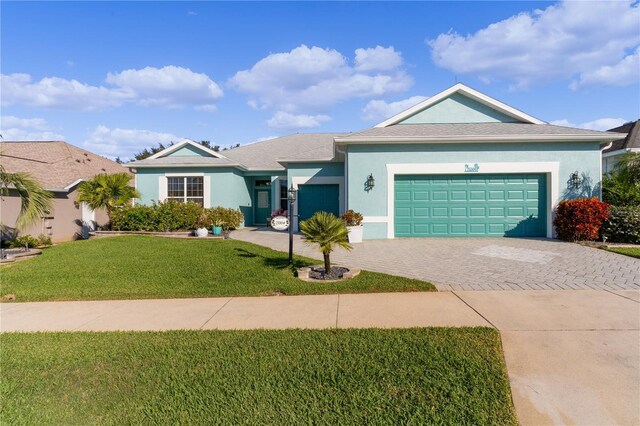 25304 Forest Oak Ct, Leesburg, FL 34748 - ranch-style house featuring stucco siding, an attached garage, a front yard, and decorative driveway